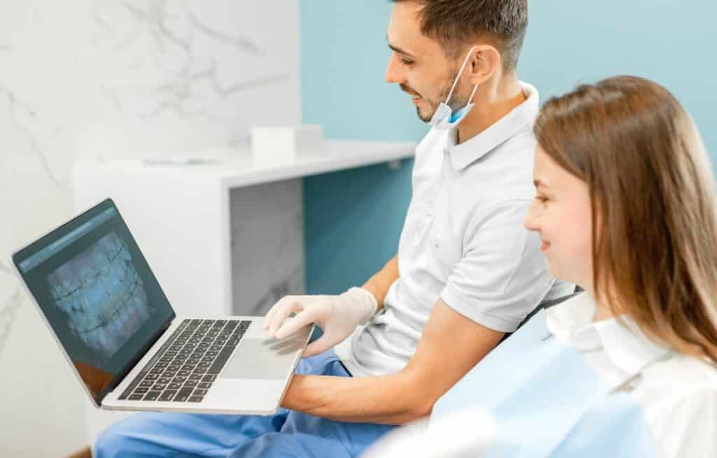 A dentist shows a patient a picture of her teeth